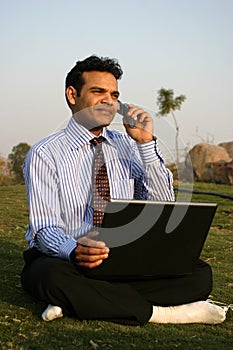 Man on mobile with laptop photo