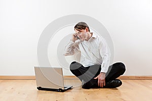 Man with mobile and laptop in his apartment