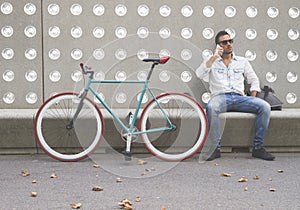 Man with mobile phone sitting on a bench in the park