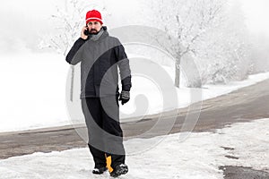 Man with mobile phone is walking across a icy street