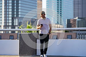 Man model in fashion in stylish polo walking on the city. Guy walks on the street. Urban fashion man in city walking