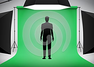 Man model standing on a green background in the photo studio with lighting setup.