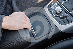 A man in a modern car. Hand raises the armrest