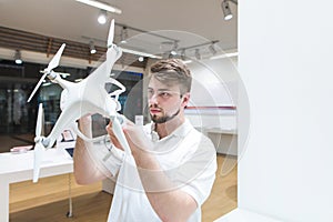 Man in a modern light dron store. Choosing and buying a quadcopter in the electronics store