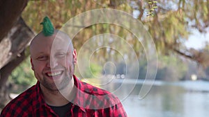 Man with mohawk laughing at camera