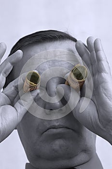 Man with money as binoculars