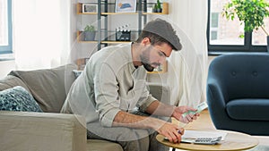 Man with money and calculator filling papers