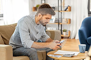 Man with money and calculator filling papers