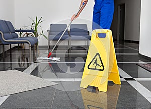 Man With Mop And Wet Floor Sign