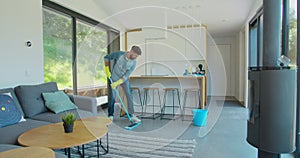 Man is mopping floor at home and having fun. Man, joy and houses concept.