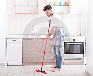 Man mopping floor in kitchen