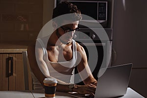 Man with morning coffee and laptop at table