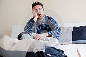Man morning wake up and yawning in bed