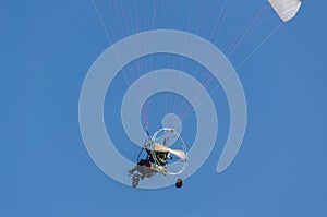 A man on a motor paraplan in a blue sky