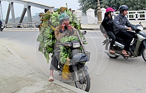 A man on motorbike in Asia with babanas