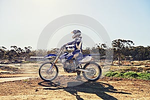 Man, motorbike and outdoor on trail for extreme sport in profile on dirt, path or countryside in summer. Person