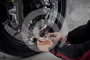 Man motorcycle tire manual air pressure testing before traveling
