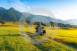 Man motorcyclist ride touring motorcycle. Alpine mountains on background. Biker lifestyle, world traveler. Summer sunny sunset day