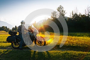 Man motorcyclist ride touring motorcycle. Alpine mountains on background. Biker lifestyle, world traveler. Summer sunny sunset day