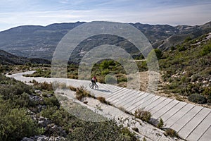 Man with mountain bike on a concrete country road.