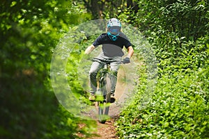 Man, mountain bike and extreme sports in forest for adventure, speed and power in park. Athlete, freedom and bicycle