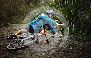 Man, mountain bike and woods with falling, ground and fitness for training, workout and red glow for injury. Forest