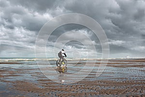 man mountain biking in autumn on the beaches of northern France with the English Channel on the horizon