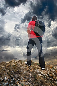 Man on the mountain edge. Tourist on mountain edge and dark sky