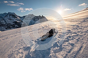 Man mountaineer climbing and crawling on snow mountain peak with sunshine in the evening at Ryten Mount