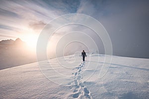 Man mountaineer walking with snow footprint on peak ridge