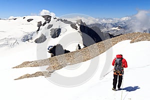 Man mountaineering with Crampons on glacier Pasterze and snow mountain panorama in Glockner Group, Austria