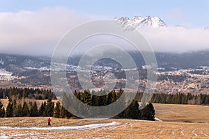 Man And Mountains. A Man In Red Jacket Against The Background Of Snow-Capped Peaks Of The High Tatras. Poprad Valley, Slovakia. Wi