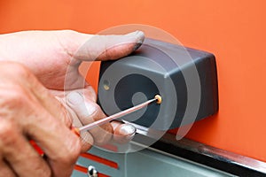 Man mounting the plastic handle protection to the body of fire truck. Man fixed handle by using screwdriver. Worker background con