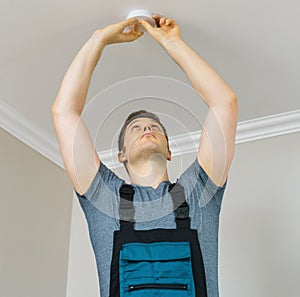 Man mounting smoke detector