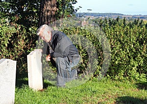 Man mourning at a cemetery.