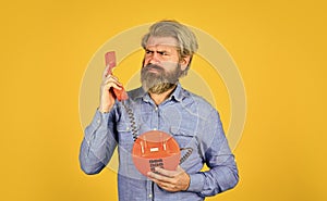 Man with moustache holding vintage phone. vintage communication device. Businessman talking on vintage phone in his