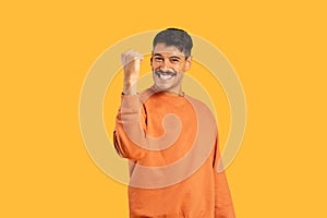 Man with moustache smiling and making a fist