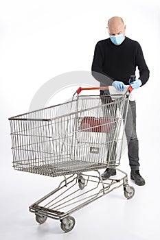 Man with mouth protection and hand gloves cleaning a shopping cart, isolated on white background