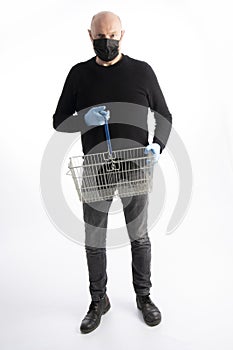 Man with mouth protection and hand gloves holding a shopping basket, isolated on white background