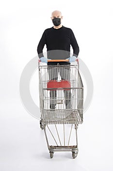 Man with mouth protection and hand gloves pushing a shopping cart, isolated on white background
