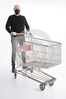 Man with mouth protection and hand gloves pushing a shopping cart, isolated on white background