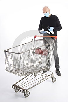 Man with mouth protection and hand gloves starting to clean a shopping cart, isolated on white background