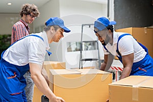 Man movers worker in blue uniform unloading cardboard boxes from truck.Professional delivery and moving service