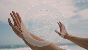 A man moves his hands in close-up and conducts against the background of sea waves. Strange hand movements reminiscent