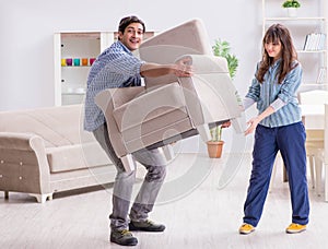 Man moving armchair in the living room