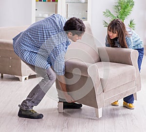 Man moving armchair in the living room