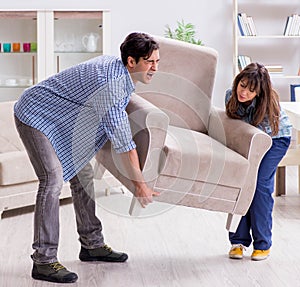 Man moving armchair in the living room