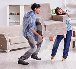 Man moving armchair in the living room