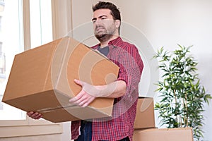 Man moving boxes and feeling back pain because heavy weight