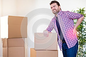 Man moving boxes and feeling back pain because heavy weight